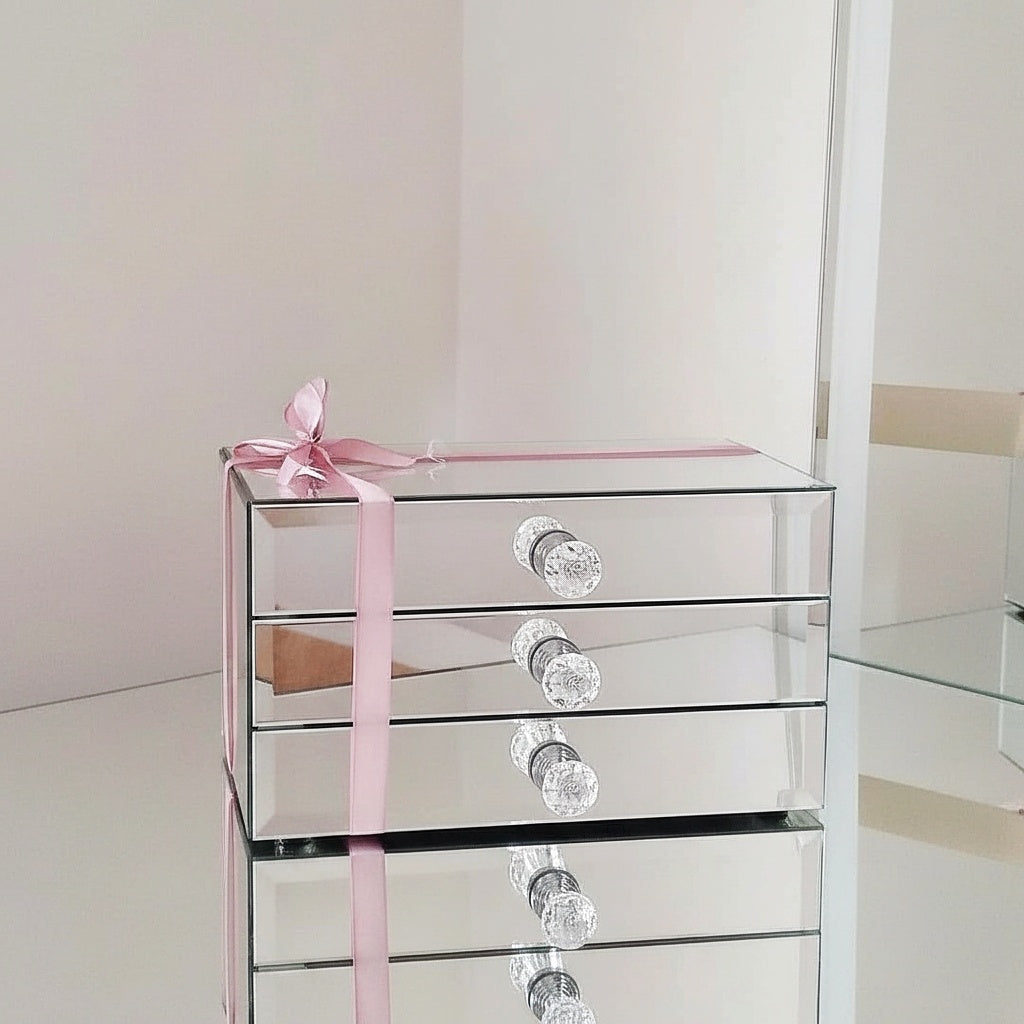Mirror organizer with 3 drawers by Mirrorina on a mirrored table, styled with a pink bow and mirror in the background.