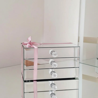 Mirror organizer with 3 drawers by Mirrorina on a mirrored table, styled with a pink bow and mirror in the background.